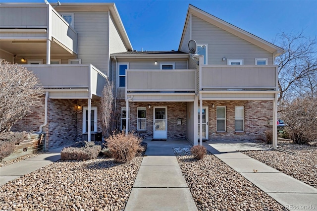 view of front of property featuring a balcony and brick siding