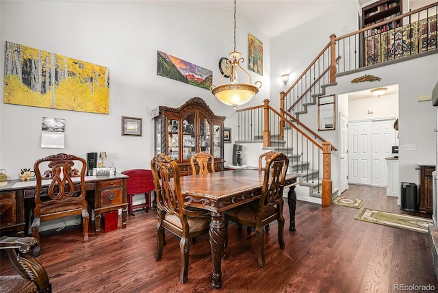 dining room featuring a high ceiling and dark hardwood / wood-style floors