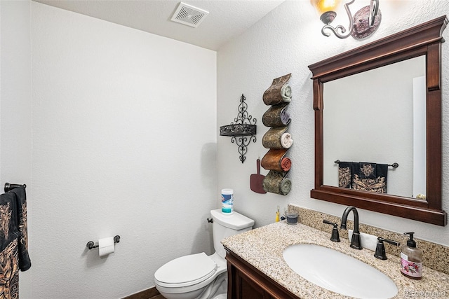 bathroom with vanity, a textured ceiling, and toilet