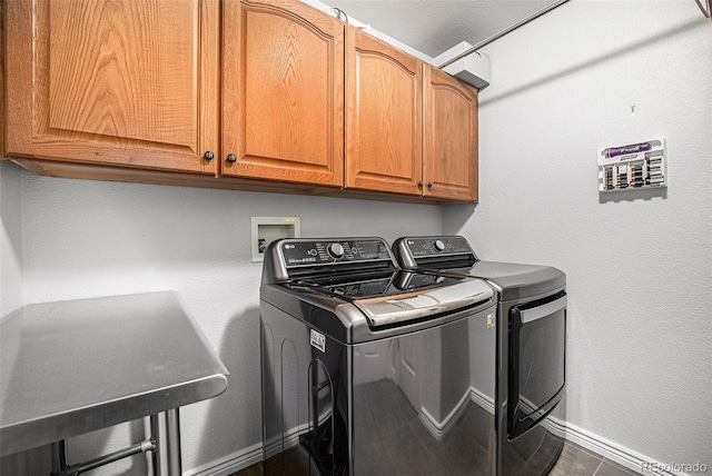 clothes washing area featuring cabinets and washer and clothes dryer