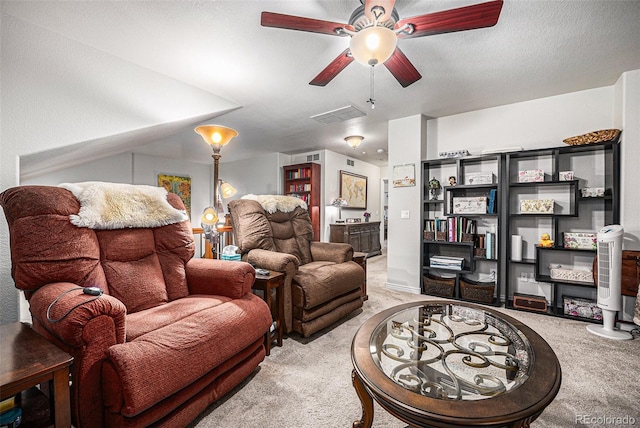 carpeted living room with ceiling fan and a textured ceiling