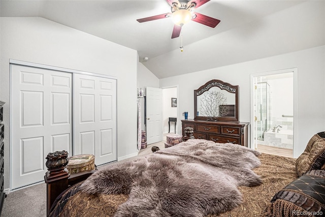 carpeted bedroom featuring ceiling fan, a closet, ensuite bathroom, and vaulted ceiling