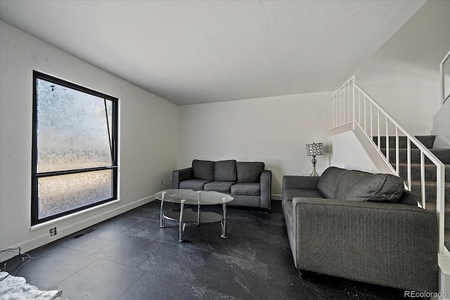 living area featuring visible vents, stairway, and baseboards