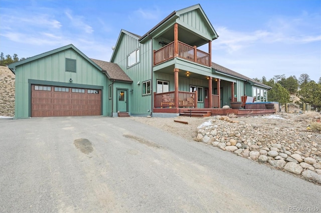 view of front of home with a balcony, aphalt driveway, and board and batten siding