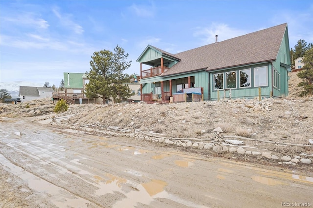 view of front of home featuring a balcony, a shingled roof, and board and batten siding