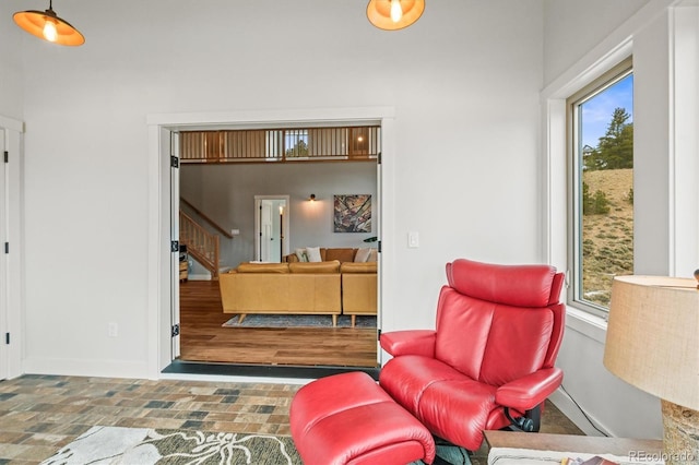 living room featuring baseboards and stairway