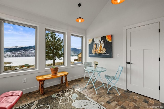 dining area with lofted ceiling, baseboards, and a mountain view