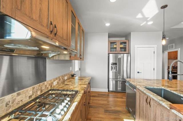 kitchen with brown cabinets, visible vents, stainless steel appliances, and a sink