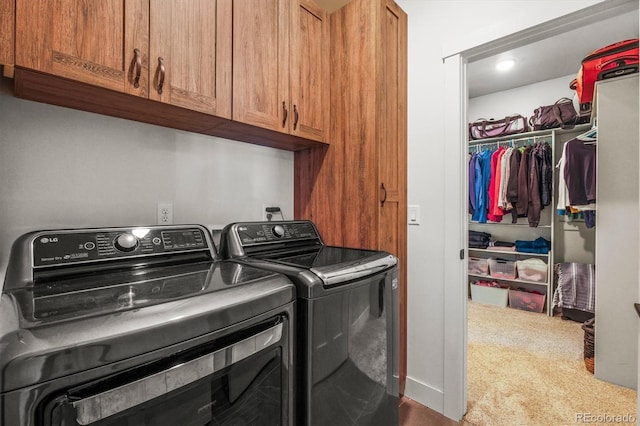 clothes washing area featuring carpet floors, cabinet space, and washer and dryer