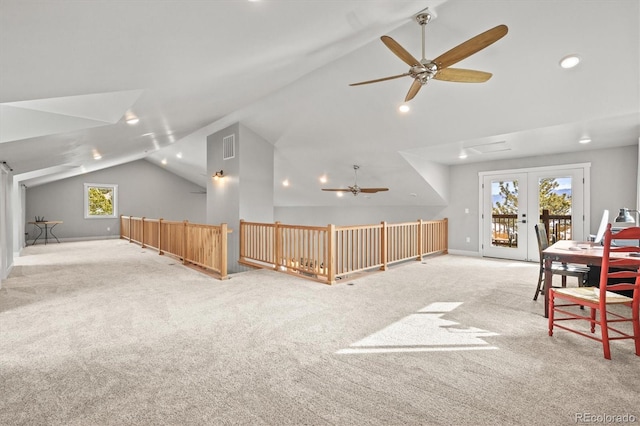 interior space featuring light carpet, ceiling fan, vaulted ceiling, and baseboards