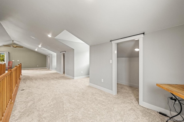 additional living space with light carpet, lofted ceiling, and baseboards