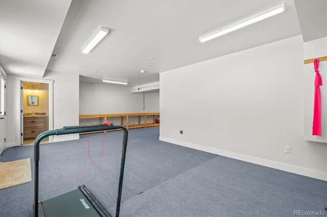 exercise area featuring carpet floors and baseboards