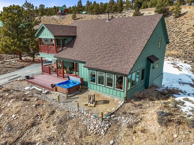 back of house with a deck, a shingled roof, and a balcony