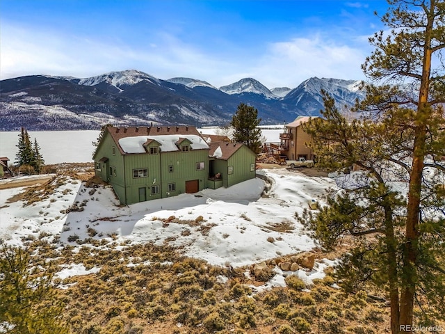 snow covered back of property with a mountain view