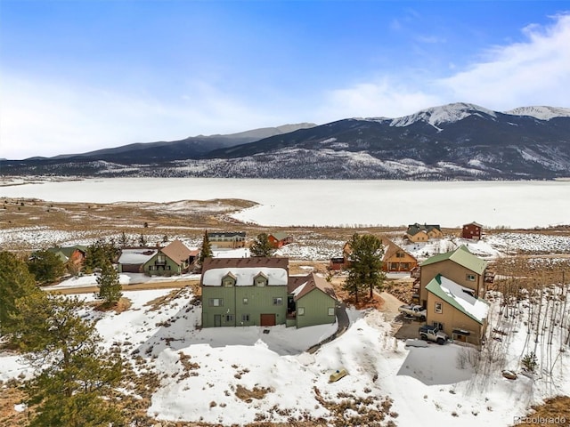 snowy aerial view with a residential view and a mountain view