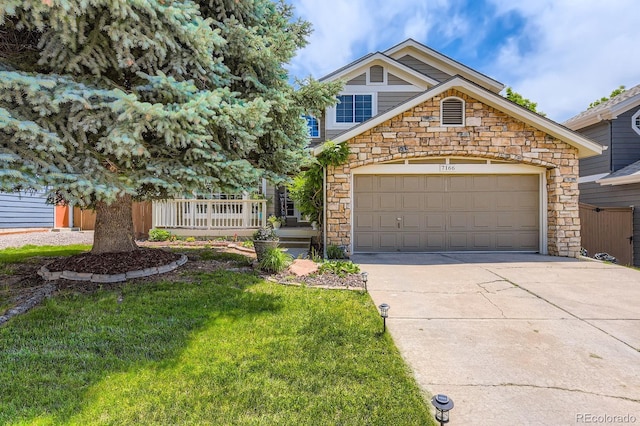 7166 Newhall Dr, Highlands Ranch, CO 80130 - view of front facade with stone siding, concrete driveway, a front yard, and an attached garage