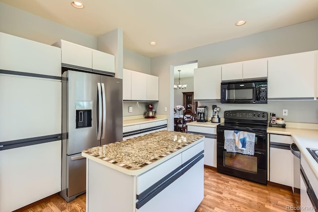 7166 Newhall Dr, Highlands Ranch, CO 80130 - kitchen with black appliances, a chandelier, white cabinets, light wood finished floors, and a kitchen island