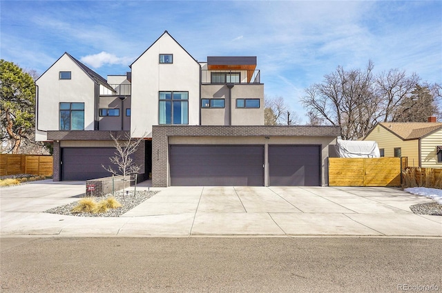 view of front of house featuring an attached garage, fence, concrete driveway, and stucco siding