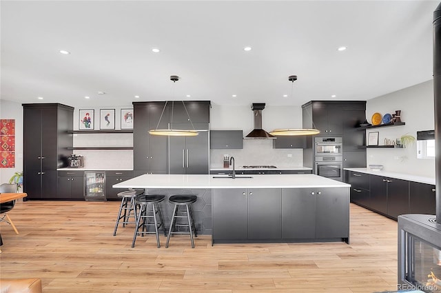 kitchen with beverage cooler, stainless steel double oven, wall chimney range hood, gas cooktop, and open shelves