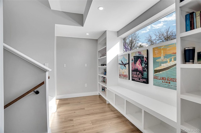 interior space featuring light wood-type flooring, built in shelves, baseboards, and recessed lighting