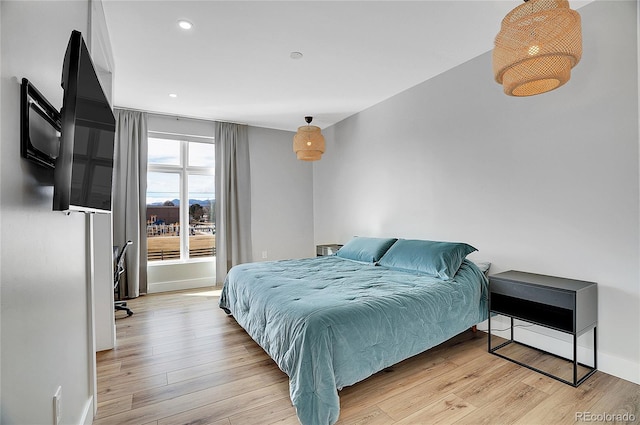 bedroom featuring light wood finished floors, baseboards, and recessed lighting