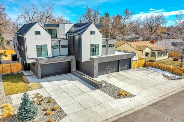 view of front of home featuring a garage, concrete driveway, fence, and stucco siding