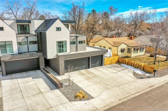 view of front of home featuring a balcony, an attached garage, concrete driveway, and stucco siding