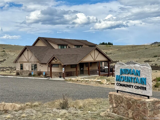 1023 Chippewa Rd, Jefferson, CO 80456 - view of front of property featuring stucco siding, covered porch, and roof with shingles