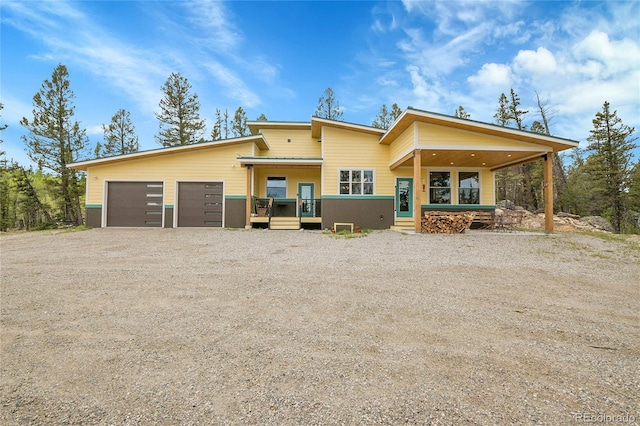 1023 Chippewa Rd, Jefferson, CO 80456 - back of house with driveway, an attached garage, and a porch