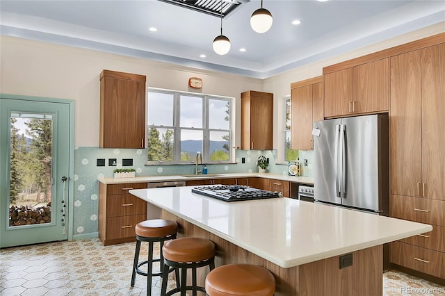 1023 Chippewa Rd, Jefferson, CO 80456 - kitchen with stainless steel appliances, a sink, a kitchen breakfast bar, light countertops, and brown cabinets