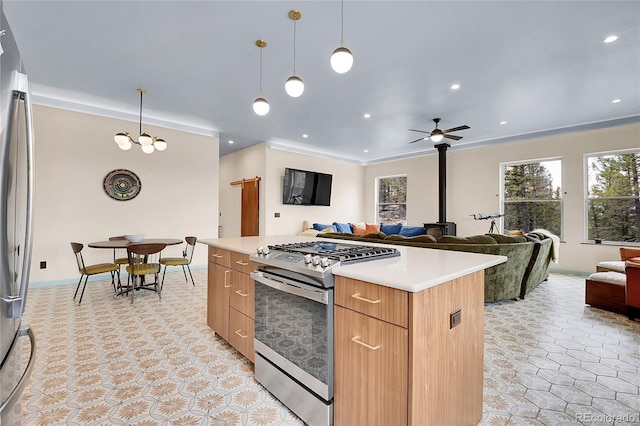 1023 Chippewa Rd, Jefferson, CO 80456 - kitchen with stainless steel gas range, a ceiling fan, open floor plan, light countertops, and hanging light fixtures