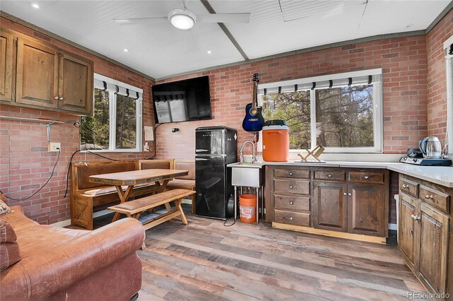 1023 Chippewa Rd, Jefferson, CO 80456 - kitchen featuring brick wall, freestanding refrigerator, light wood finished floors, ceiling fan, and light countertops