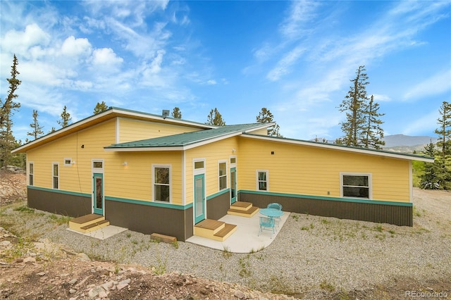 1023 Chippewa Rd, Jefferson, CO 80456 - back of property featuring entry steps, a mountain view, and a patio area