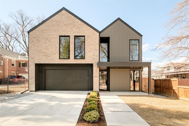 view of front of home with driveway, brick siding, an attached garage, and fence