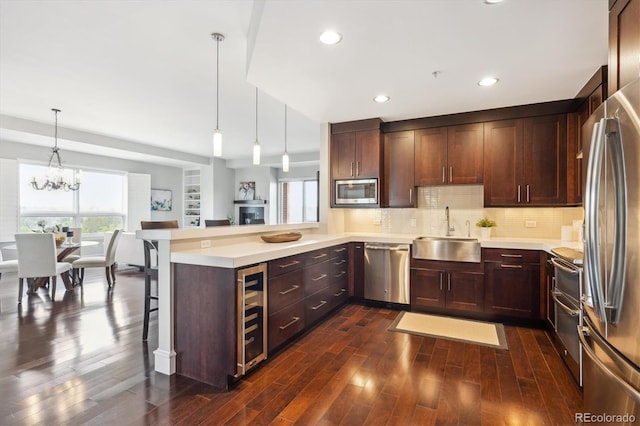 4875 S Monaco St Unit 303, Denver, CO 80237 - kitchen featuring a sink, stainless steel appliances, wine cooler, healthy amount of natural light, and recessed lighting