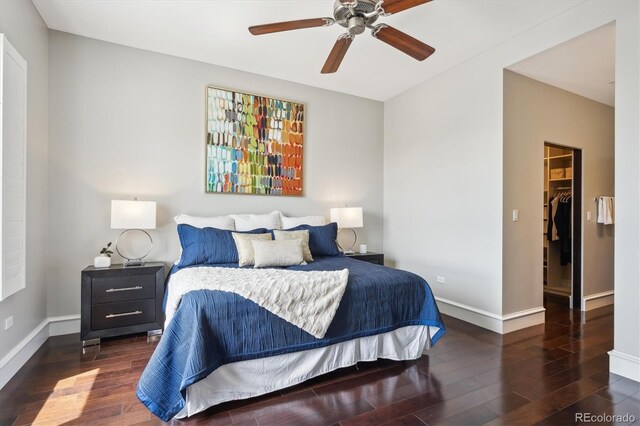 4875 S Monaco St Unit 303, Denver, CO 80237 - bedroom featuring wood finished floors, baseboards, a walk in closet, and ceiling fan