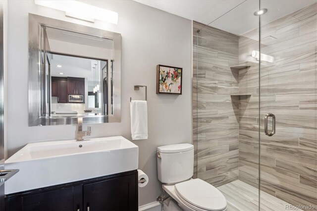 4875 S Monaco St Unit 303, Denver, CO 80237 - full bath featuring toilet, a shower stall, vanity, and baseboards