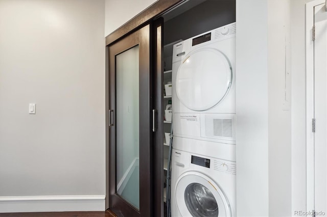 4875 S Monaco St Unit 303, Denver, CO 80237 - laundry area featuring stacked washer / dryer and baseboards