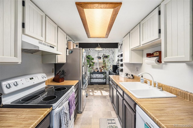 kitchen featuring under cabinet range hood, light countertops, electric stove, white cabinetry, and a sink