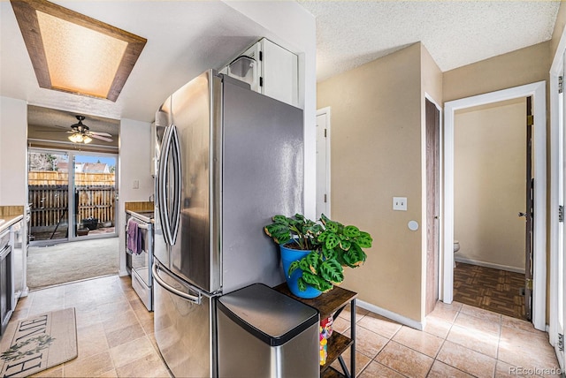 kitchen with baseboards, freestanding refrigerator, electric range, white cabinets, and a textured ceiling