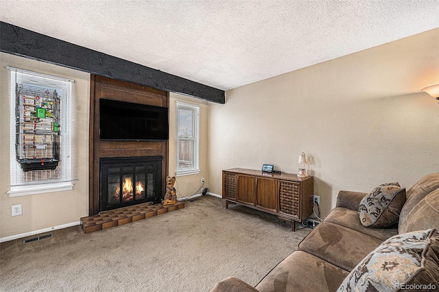 carpeted living room with visible vents, a textured ceiling, and a large fireplace