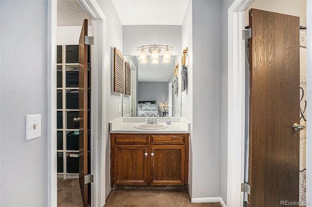 bathroom with vanity, ensuite bathroom, and a textured ceiling