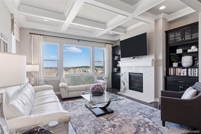 living room featuring coffered ceiling, wood finished floors, a premium fireplace, and beamed ceiling