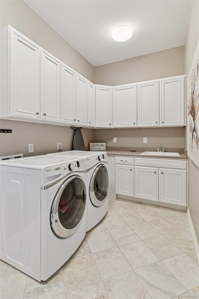 laundry room with a sink, light tile patterned floors, independent washer and dryer, and cabinet space