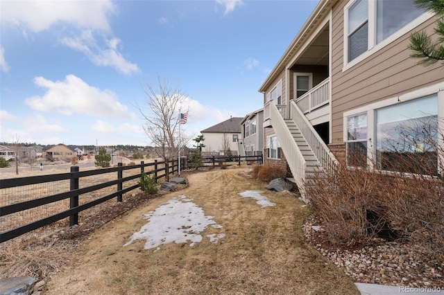 view of yard with stairs, fence, and a residential view