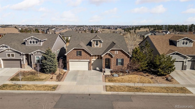 view of front of house with a residential view, stone siding, driveway, and a garage