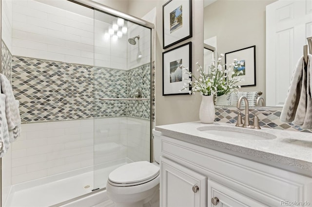 full bath with vanity, a stall shower, and toilet