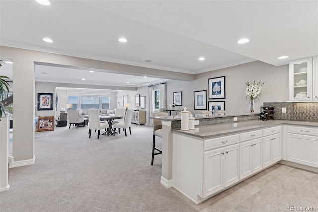 kitchen with recessed lighting, open floor plan, light colored carpet, and ornamental molding