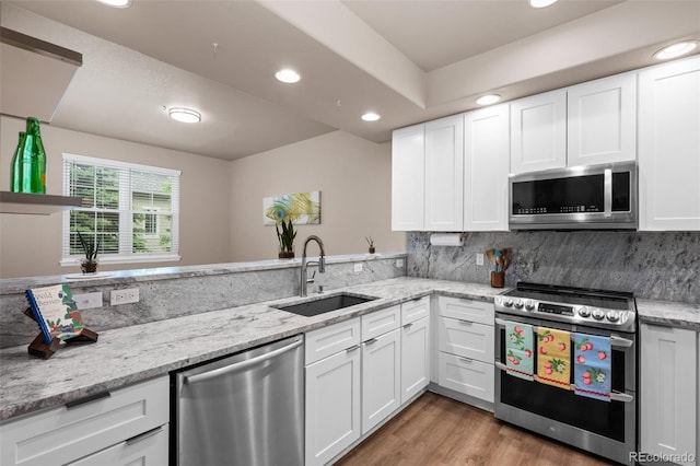 12919 W Burgundy Dr, Littleton, CO 80127 - kitchen featuring stainless steel appliances, recessed lighting, white cabinetry, tasteful backsplash, and light stone countertops