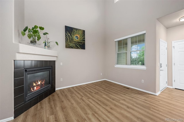 12919 W Burgundy Dr, Littleton, CO 80127 - unfurnished living room featuring wood finished floors and a tiled fireplace